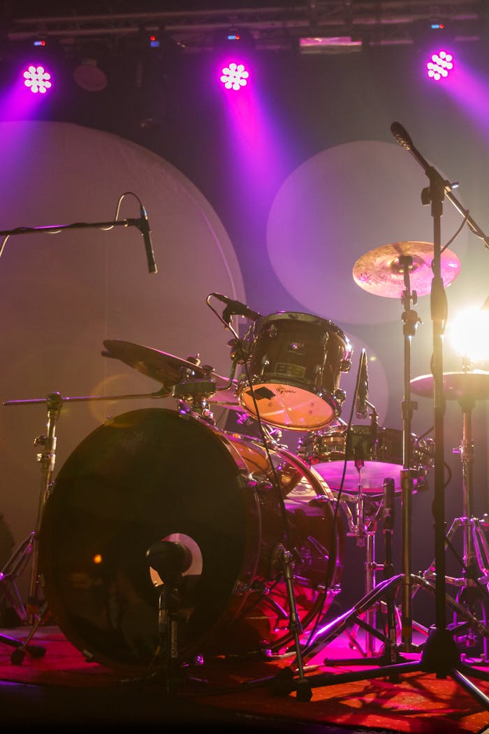 Close-up of a drum set on stage with vibrant lights in Bucharest. Perfect for music and concert themes.